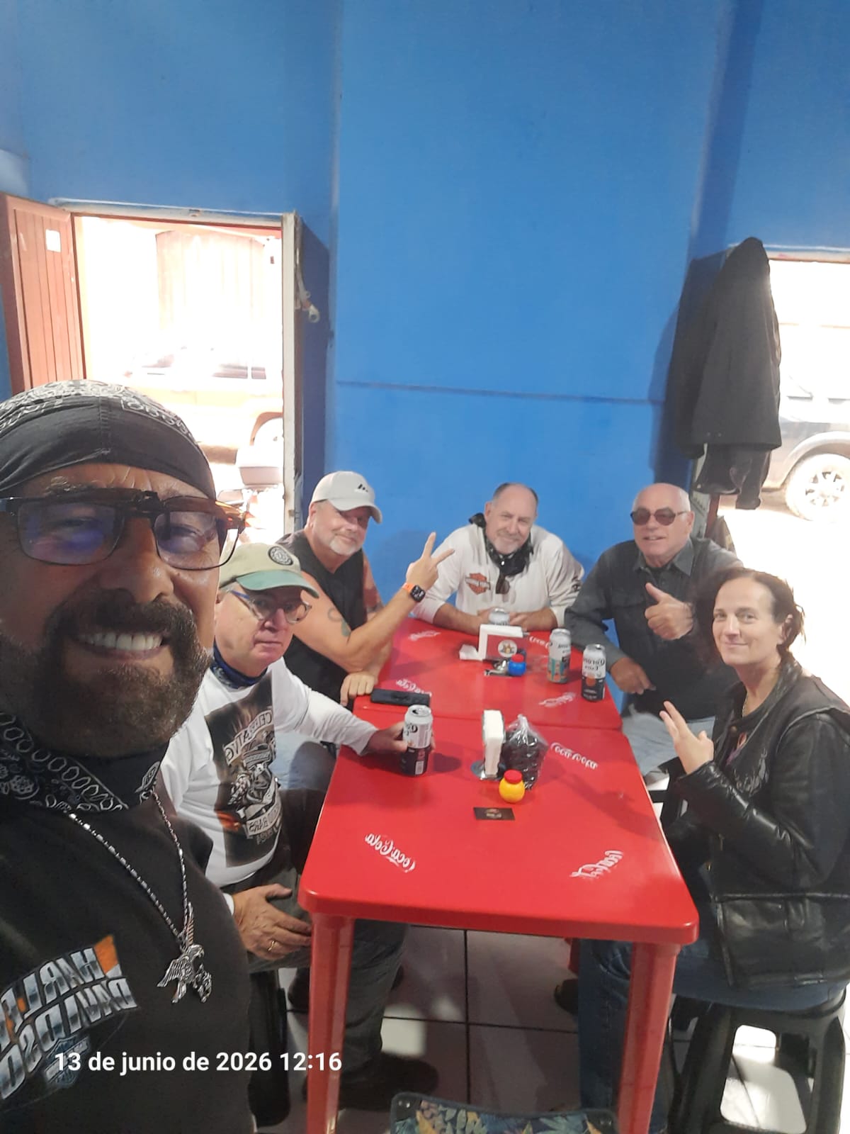 Los Güeros members sharing birria and hamburgers around a table in Concepción de Buenos Aires